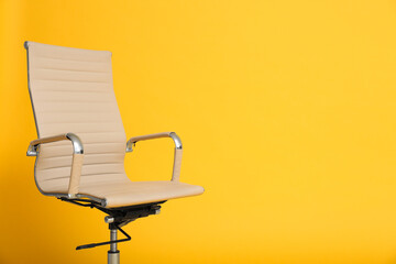 Modern office chair on yellow background. Space for text