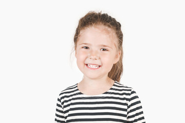 Cute smiling girl looking at camera. Posing little girl wearing striped shirt.