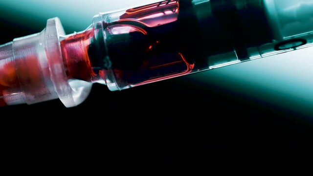 A surgical syringe injects the virus. Infected blood. Macro frame
