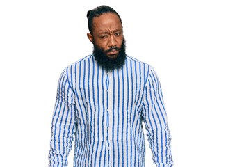 Young african american man wearing business shirt skeptic and nervous, frowning upset because of...