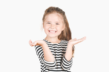 Cute laughing girl looking at camera. Happy girl with wide smile and hands up shouting Surprise, Win. Posing little girl wearing striped shirt. Celebrating concept.