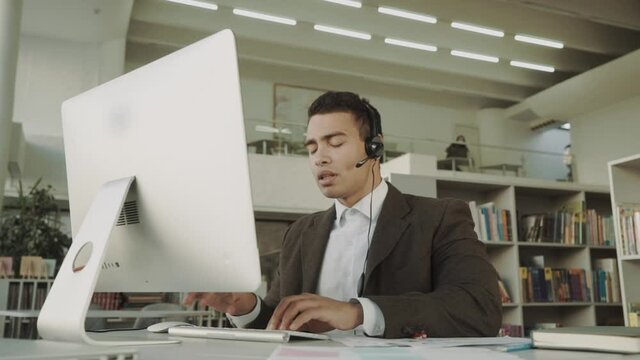 customer support operator with hands-free headset working in the office, mixed race employee