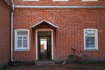 Fototapeta premium Window and entrance on a red brick wall.