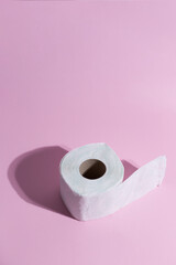 Toilete paper on a pink background. Minimal concept.