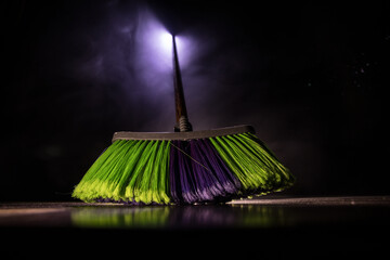 close-up brush the floor on a dark background with light and fog. Broom in dark. Cleaning concept.