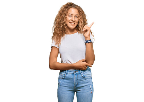 Beautiful caucasian teenager girl wearing casual white tshirt pointing finger up with successful idea. exited and happy. number one.