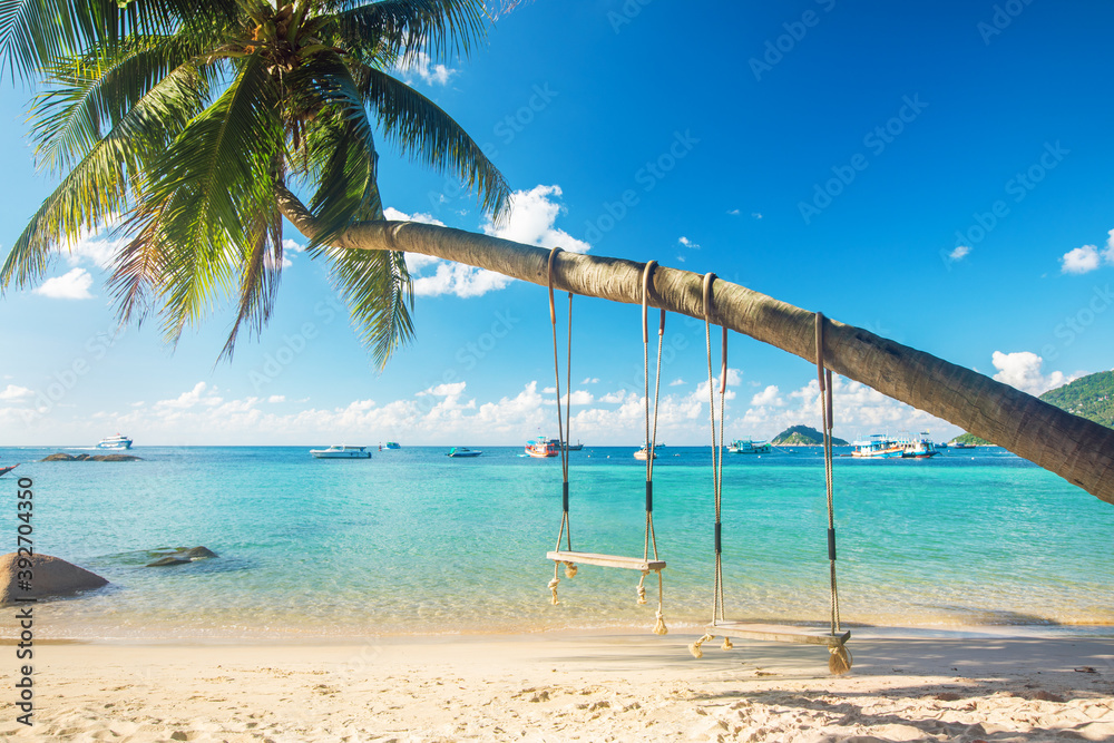 Wall mural beautiful tropical island beach with coconut palm trees and two swings, koh tao, thailand