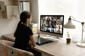 Back rear view happy millennial female employee looking at computer monitor, holding online video...