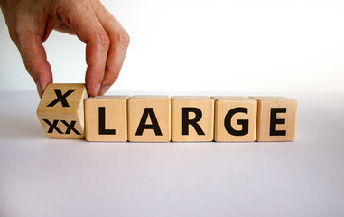 Reducing weight concept. Hand turns a cube and changes the words 'XX Large' to 'X Large'. Beautiful white background. Business and lifestyle concept. Copy space.