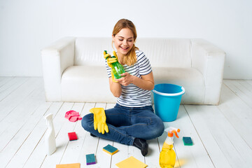 Woman sitting on the floor with cleaning supplies cleaning service housework