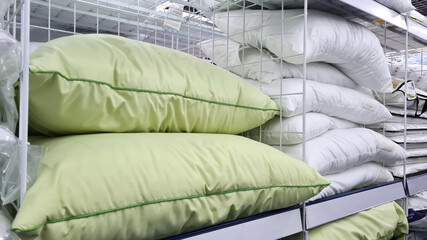Fototapeta premium Many beautiful green and white pillows sells on a shelf in store.