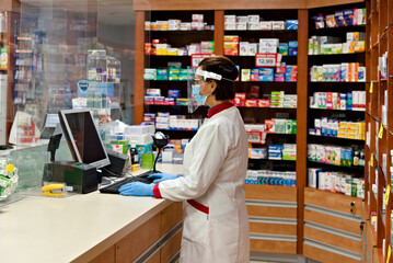 Pharmacist dispensing drugs in a pharmacy. - obrazy, fototapety, plakaty