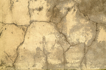Beige old concrete wall with many long cracks. Urban style. Copy space. Cracked texture, abstract background.