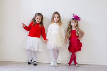 beautiful fashionable children stand at the white wall