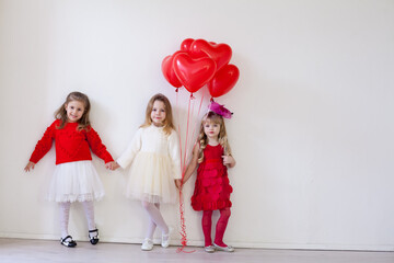 Children's friends sit with red balloons at the holiday birthday