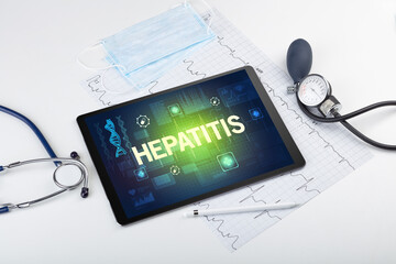 Tablet pc and medical stuff with HEPATITIS inscription, prevention concept