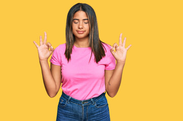 Young latin girl wearing casual clothes relax and smiling with eyes closed doing meditation gesture with fingers. yoga concept.