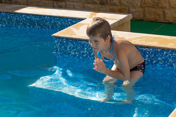 boy getting ready to jump under the water in the pool