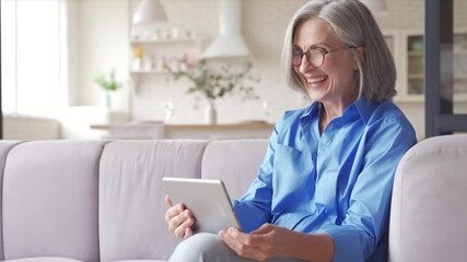 Happy old senior woman grandmother holding digital tablet video conference calling talking enjoying social distance party, virtual family online chat meeting with grandchildren on holiday at home. - Powered by Adobe