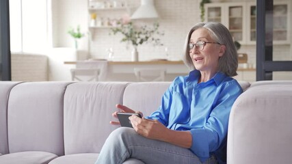 Old senior middle aged woman grandmother holding cell phone video conference calling in mobile app talking with social distance family or doctor in virtual online chat meeting on smartphone at home.