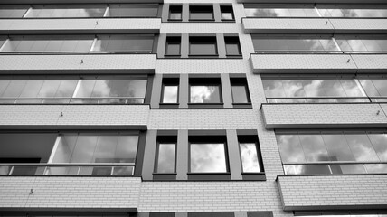 Detail of modern residential flat apartment building exterior. Fragment of new luxury house and home complex. Black and white.