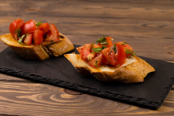 Fresh tomato bruschetta. italian appetizer with basil on wooden background