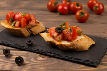 Fresh tomato bruschetta. italian appetizer with basil on wooden background