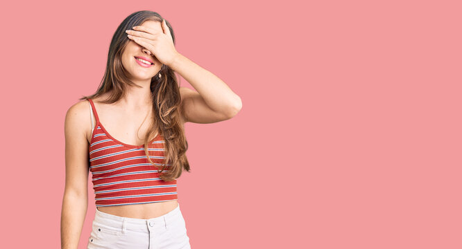 Beautiful caucasian young woman wearing casual clothes smiling and laughing with hand on face covering eyes for surprise. blind concept.