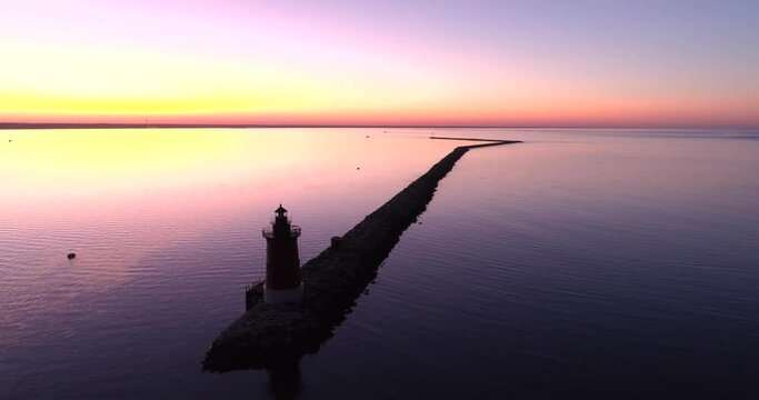 Beautiful sunset of the Delaware Bay with the silhouette of a lighthouse, aerial drone shot