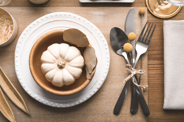 Autumn table setting with pumpkin and decor on wooden background, flat lay