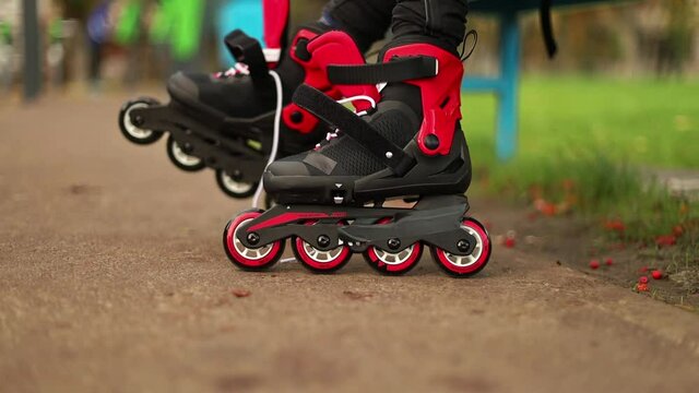 Closeup video of roller skating girl in park rollerblading on inline skates. Caucasian female kid in outdoor activities.