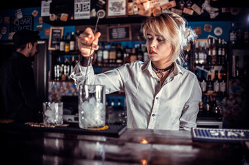 Girl bartender concocts a cocktail at the public house