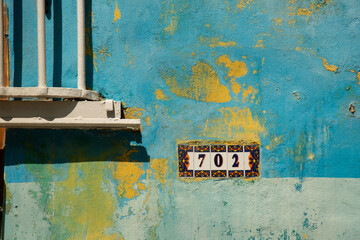 Textured blue and yellow wall with tiles number