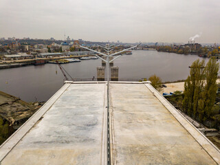 Fototapeta na wymiar Aerial drone view. The edge of an unfinished bridge in Kiev. Cloudy autumn morning.