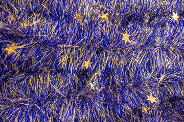 christmas festive background of blue foil garlands close up