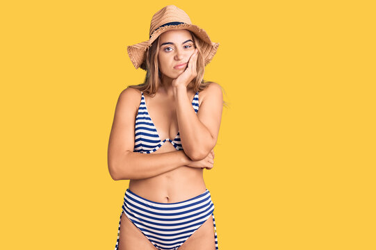 Young beautiful blonde woman wearing bikini and hat thinking looking tired and bored with depression problems with crossed arms.