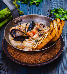 Mixed seafood saute served with toasted bread in a pan