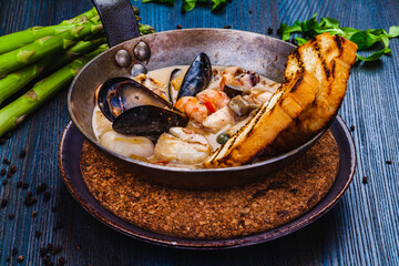 Mixed seafood saute served with toasted bread in a pan