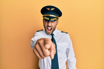 Handsome hispanic man wearing airplane pilot uniform pointing displeased and frustrated to the camera, angry and furious with you © Krakenimages.com