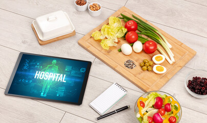 HOSPITAL concept in tablet with fruits, top view