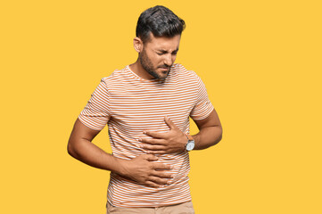 Handsome hispanic man wearing casual clothes with hand on stomach because indigestion, painful...