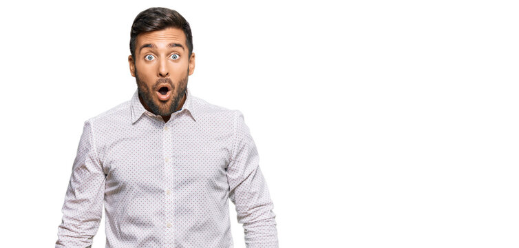 Handsome hispanic man wearing business clothes scared and amazed with open mouth for surprise, disbelief face