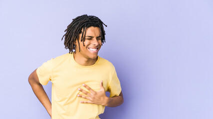 Young african american rasta man laughing keeping hands on heart, concept of happiness.