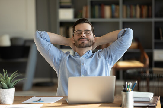 Relaxed man take break from work put hands behind head lean on comfy chair closing eyes feels serenity, enjoy fresh conditioned air in modern office, no stress, fatigue relieve at workplace concept