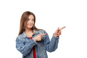 A nice young woman points her fingers to the right. Copy space on the right. White isolated background.