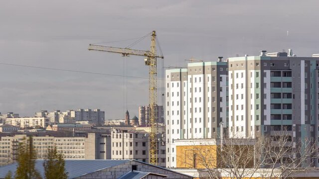 Crane and building construction site in a big city aerial timelapse during all day. Workers laying briks walls of new residential appartment house