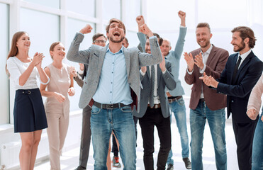 happy young businessman standing in front of his business team.