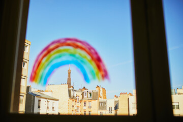 Colorful rainbow painted on window glass in Parisian apartment, Eiffel tower is seen in the background