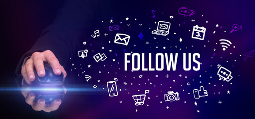 hand holding wireless peripheral with FOLLOW US inscription, social media concept