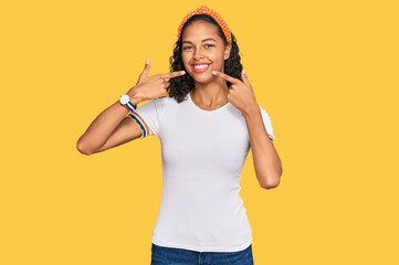 Young african american girl wearing casual clothes smiling cheerful showing and pointing with fingers teeth and mouth. dental health concept.